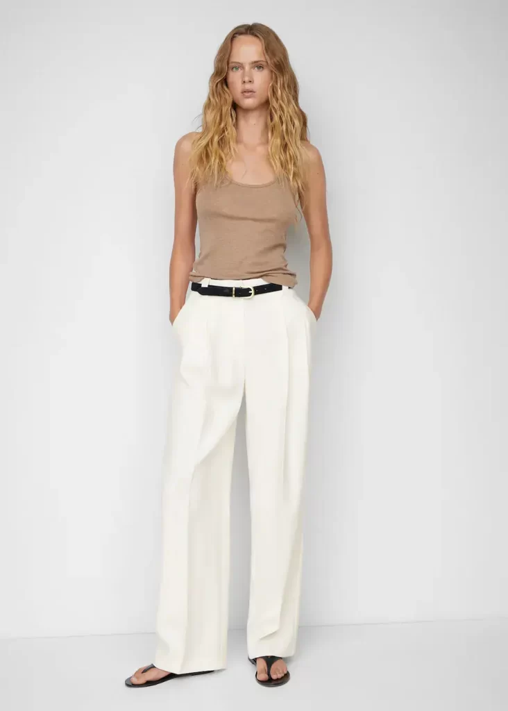 woman wearing tank top and white wide legged pleated pants